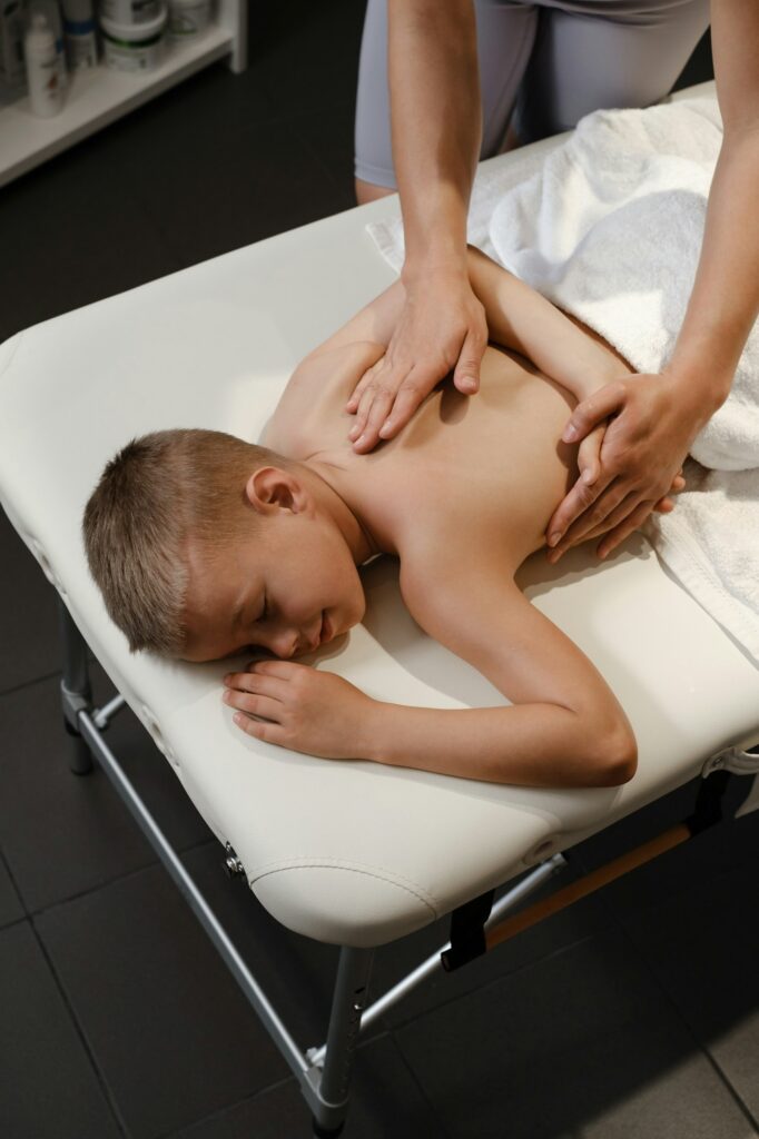 Children massage in clinic. Boy having physical therapy