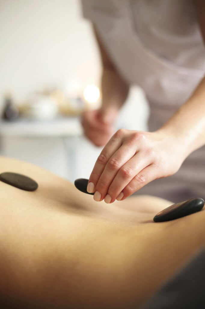 Woman during hot stone massage in spa salon